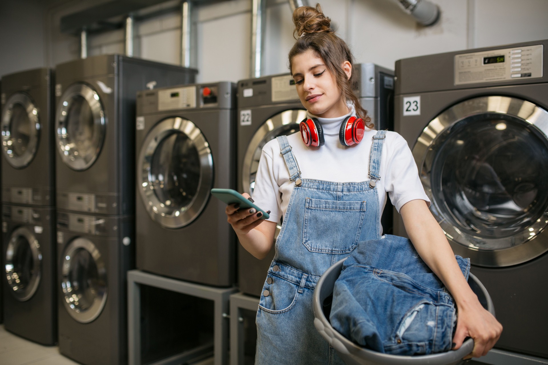 Young Caucasian woman doing laundry at the laundromat